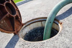 Open manhole with suction hose